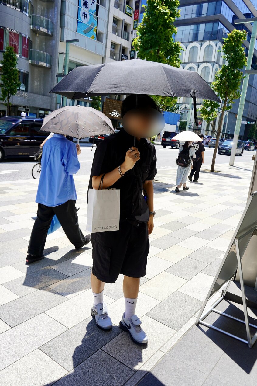 ユニクロで買ったという日傘をさしていた男性。画像を一部加工しています（撮影/上田耕司）