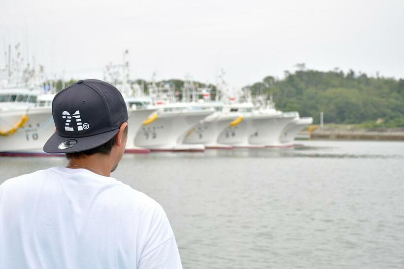 福島県漁業の主力と言われる沖合底引き網漁船が松川浦に並ぶ。菊地基文（後ろ姿）は、７、８月の休漁期、網や部品整備に忙しい（撮影・遠藤智哉）