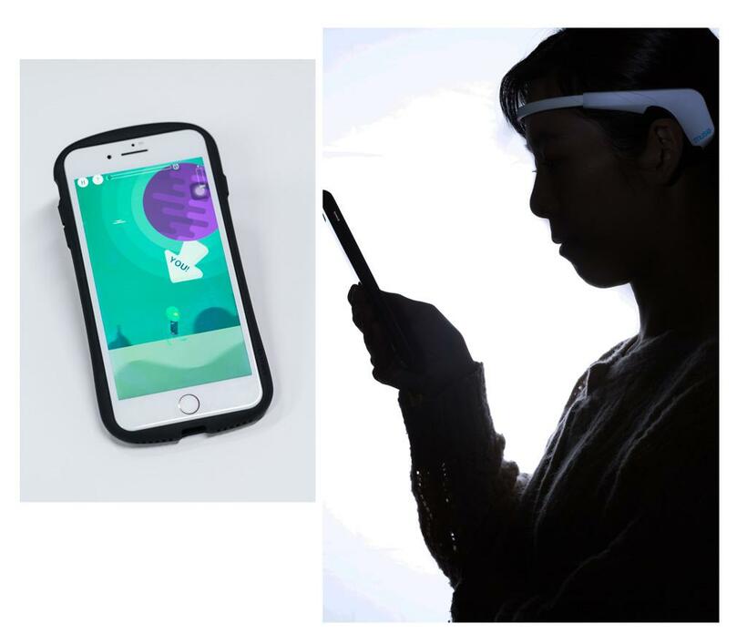 脳波測定器を頭部に装着し、ゲームアプリ「マインドリフト」をセット（右）。ユーザーの脳波状態に連動する黒服の宇宙人キャラクターの速度アップを図る（上）。アプリの利用料金はメニューごとに月額税別3千円（撮影／写真部・張溢文）