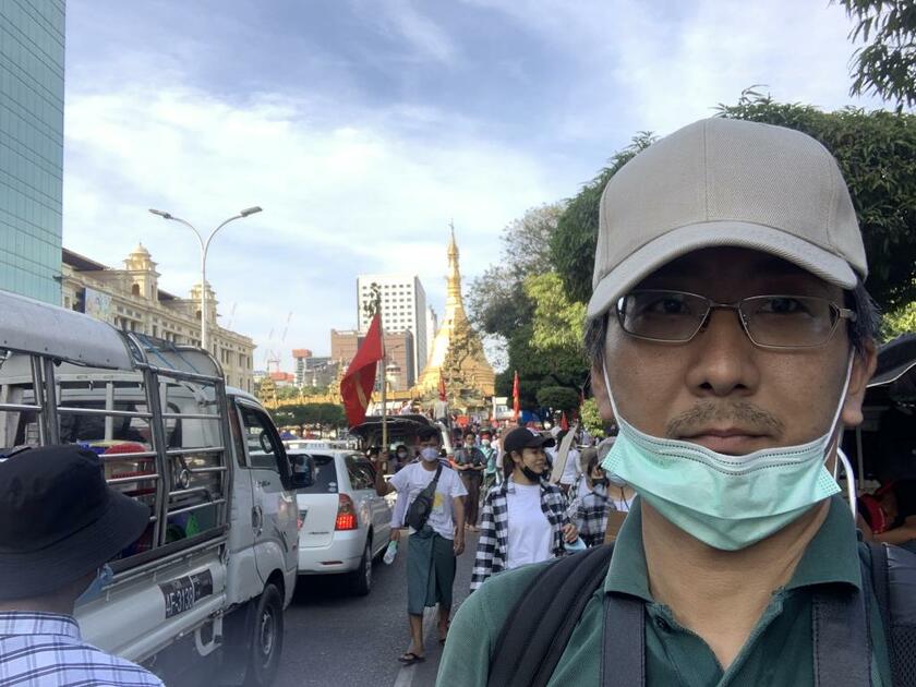 北角裕樹さん（４７）／２０２１年２月、クーデターの後、ミャンマーのヤンゴンにあるスーレーパゴダ付近で抗議デモを取材する様子。この約２カ月後に、約１カ月間、拘束された（写真：本人提供）