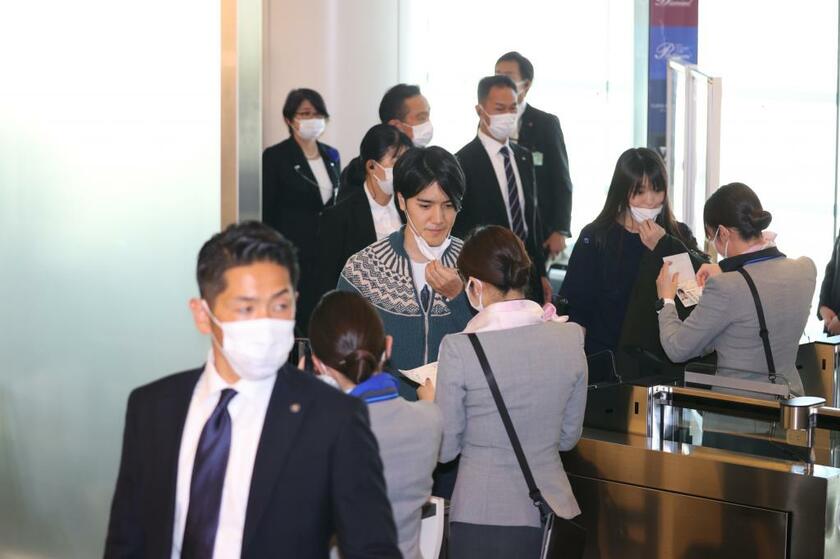 羽田空港の出国時にマスクを下す小室眞子さと圭さん（写真部・松永卓也）