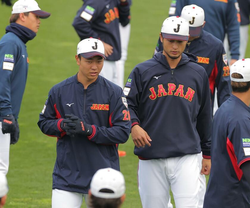 練習前に話す侍ジャパンの高橋宏斗（左）とダルビッシュ有（2月18日、ひなたサンマリンスタジアム宮崎）