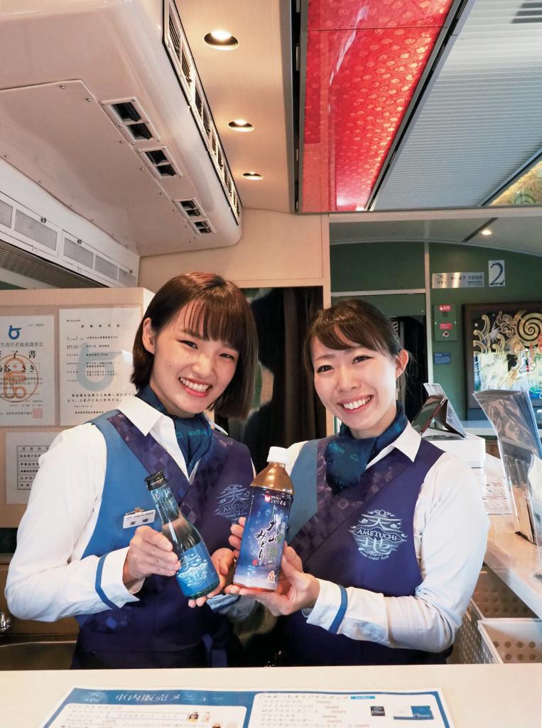 「あめつち」アテンダントの前田裕美さん(右)と家郷萌さん。手にするのは地酒「天地」と日本茶「大だ い山せんみどり」。事前に予約すれば「山陰の酒と肴」や「松江の和菓子詰合せ」などを楽しむことができる。ちなみに酒の肴は、島根牛のローストビーフ、宍道湖産しじみ入り玉子焼き、出雲そばの素揚げ、境港産紅ズワイガニなど、山陰の美味満載■オリンパスOM-D E-M1 MarkII・12~100ミリF4・絞りf5.6・ISO6400・AE・JPEGスーパーファイン(写真/櫻井寛)