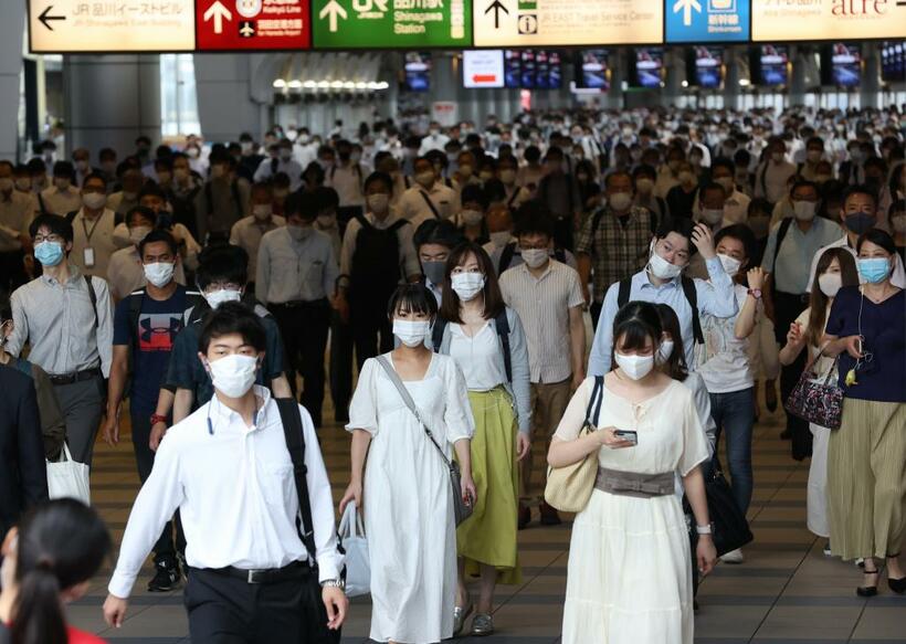 感染対策にマスクを着用し、出勤する人々。新型コロナウイルスに感染後も症状の残る人が一定数いることが各国で報告されており、国内でも近く調査が始まる　（ｃ）朝日新聞社
