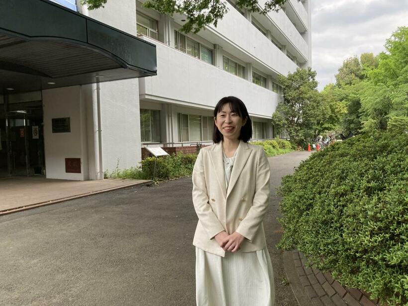 村松里衣子さん＝国立精神・神経医療研究センター神経研究所の建物の前