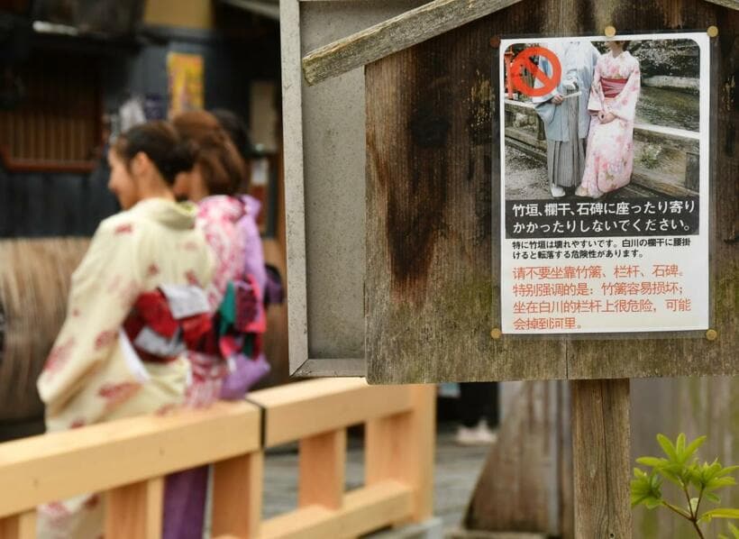 京都の伝統ある町並みは格好の“インスタスポット”。マナー違反が増えるにつれ、無粋な看板も立てられるようになり、景観が損なわれていく／２０１９年３月、京都市東山区で　（ｃ）朝日新聞社