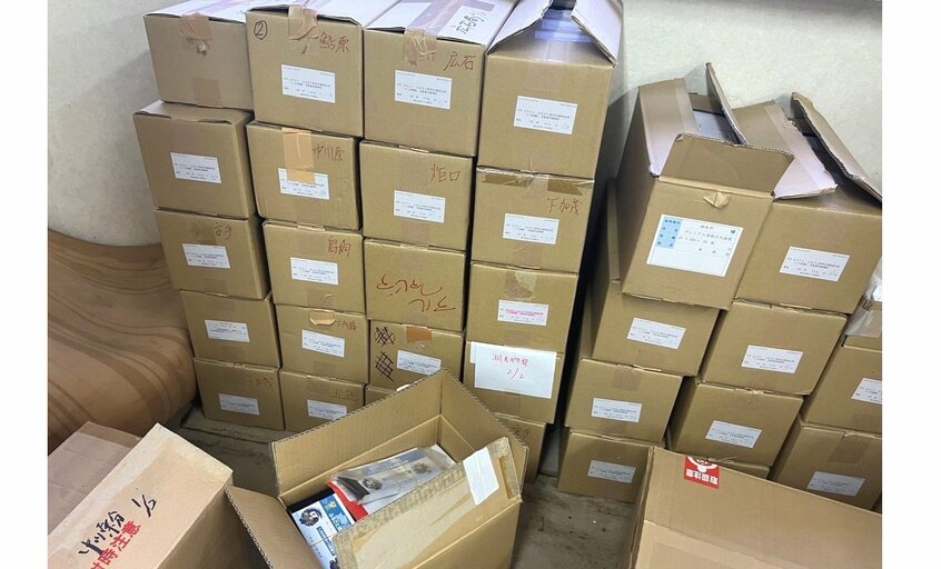 山積みになった商品券が入った段ボール