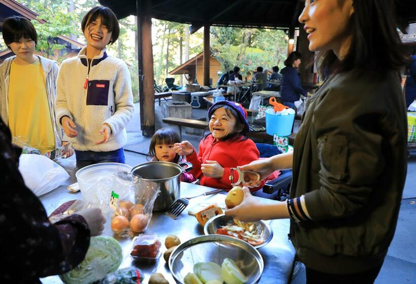 キャンプにはまっているのは、「小さい頃に連れて行ってもらえなかったからかな」。重いものは持てないし、抱っこをお願いすることもあるが、企画や予約、役割分担などを担当し、輪の中心にいる（撮影／松永卓也）