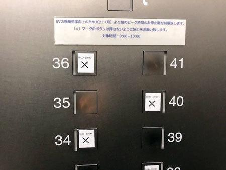 エレベーター内の階数ボタン。「9:00～10:00」の時間帯に押してはいけない階数には、シールを貼って対策を行った。このエレベーターには、偶数階に停止させないようシールが貼ってある