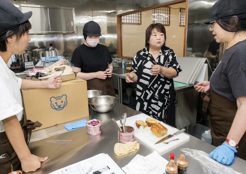 右から２人目が竹田恵子さん。オープン間近の「めぐみキッチン」でメニューを確認中。昼はカフェ、夕方からは常設の子ども食堂に（撮影／横関一浩）