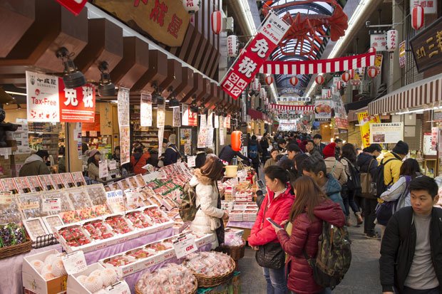 「免税御礼」の文字がはためく黒門市場。現在、およそ１５０の商店が軒を連ねる。商店街振興組合では、有志を募って語学教室も始め大好評。言葉が通じるようになったおかげで売り上げが前年比５倍になった店もあるとか（撮影／楠本涼）