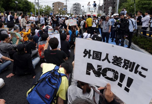ヘイトスピーチのデモに対し、プラカードを掲げて座り込む人たち=２０１６年（ｃ）朝日新聞社