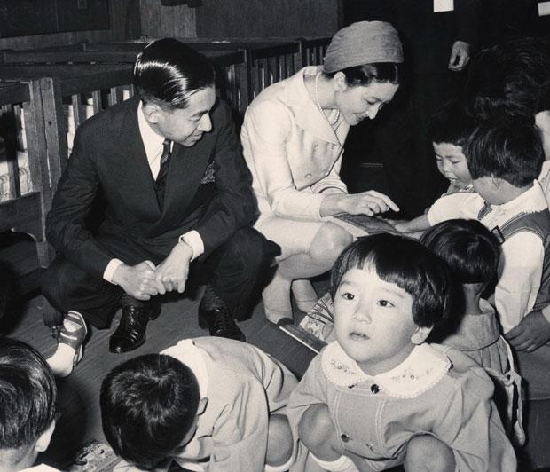 「赤十字子供の家」で生活する子どもたちに語りかける皇太子と美智子妃。皇太子(当時)もしゃがんで目線を合わせている/1968年5月8日、東京都世田谷区で (c)朝日新聞社