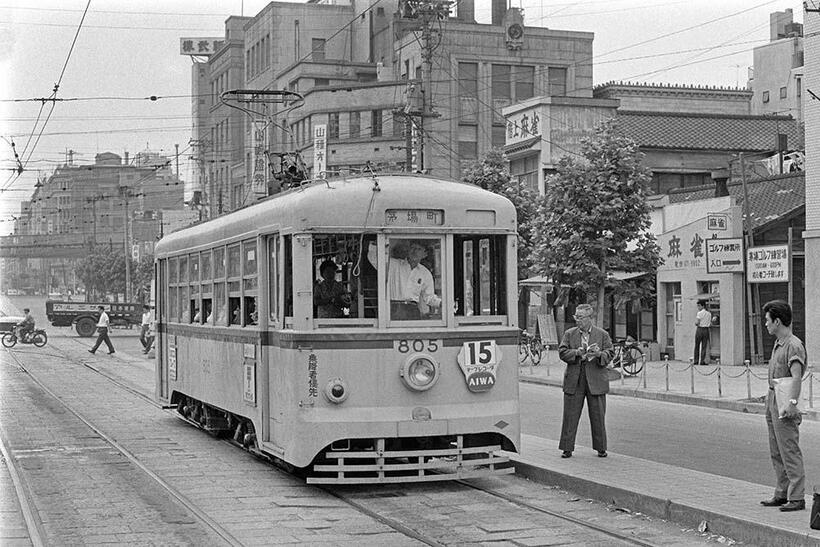 1963年になると前掲の茅場町停留所は茅場町交差点の東側に移設された。画面右側の低い家並が日本橋茅場町、背景の証券会社ビル街が日本橋兜町で、「日本橋」を冠した地名が現在も脈々と息づいている。茅場町停留所（撮影／諸河久：1963年7月22日）