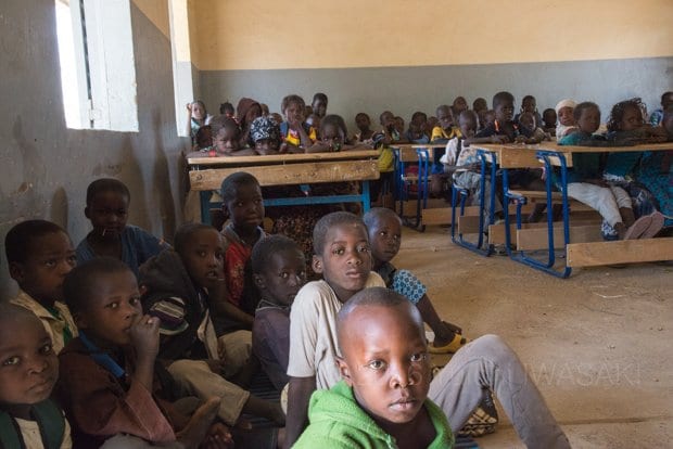 教室にかろうじて残った机と椅子では数が足りず、子どもたちは床に座って授業を受けざるをえない。筆記用具も教科書もなく、黙って先生の授業を聞いていた（ニャフンケ・マリ 2016年／Niafunke,Mali 2016）