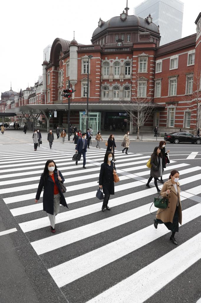３月２７日朝、東京・丸の内は通勤客がまばらだった。JR東京駅前の横断歩道を渡る人たち　（ｃ）朝日新聞社