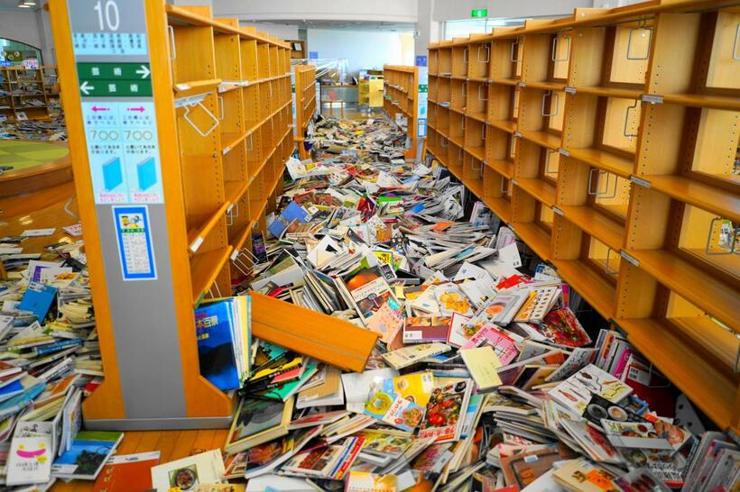 ２月１３日、最大震度６強の地震に見舞われた福島県新地町。町内の図書館では、落下した書籍で足の踏み場もないほどに（ｃ）朝日新聞社