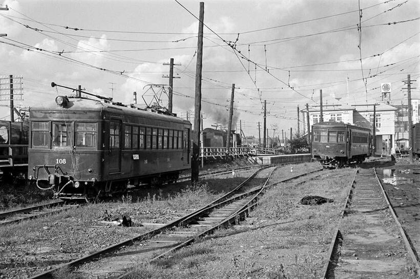 旭川四条駅に待機する東川行きの電車。その背後を宗谷本線の貨物列車が通過していった。右側に停まっているのはラッシュ時に増結する客車で、旧国鉄キハ05型からの改造車だった。（撮影／諸河久：1967年10月3日）