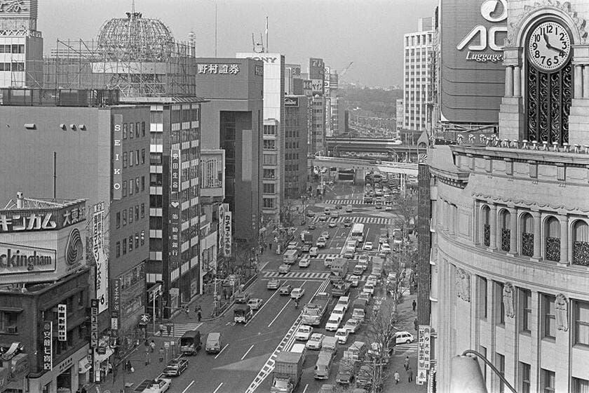 今昔対比撮影は銀座三越の取材協力で実施され、地球儀広告塔の解体作業が始まった絶好のタイミングだった。数寄屋橋方面の高架橋を走る東海道新幹線も画面の中に取り込んだ。（撮影／諸河久：1983年1月25日）