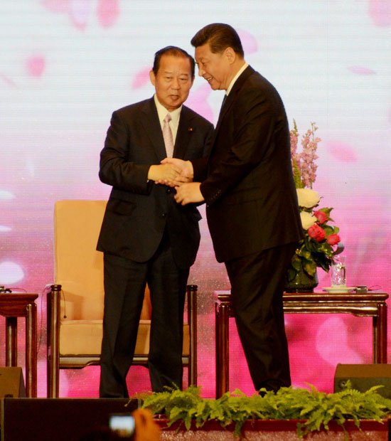 北京の人民大会堂で５月２３日、がっちり握手する習主席と二階総務会長　（ｃ）朝日新聞社　＠＠写禁
