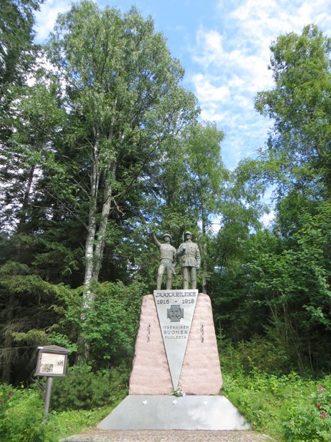 カヤーニ　　志願兵記念像。第一次世界大戦時、フィンランドの独立を夢見た大学生やエリート層の若者たちの間で、志願兵運動が展開された。彼らはここで出会い、ドイツに渡り軍事訓練を受けた。フィンランド独立後の内戦では白衛軍で活躍し、ソ連の支援を受けた赤衛軍に勝利した