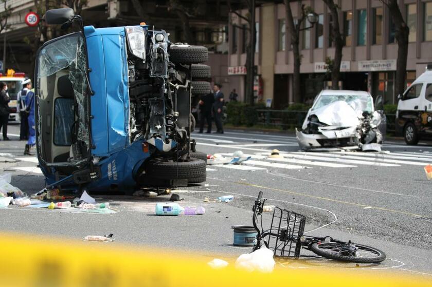 ４月１９日、東京・池袋の交差点で衝突、横転したごみ収集車。後方は大破した乗用車　（ｃ）朝日新聞社