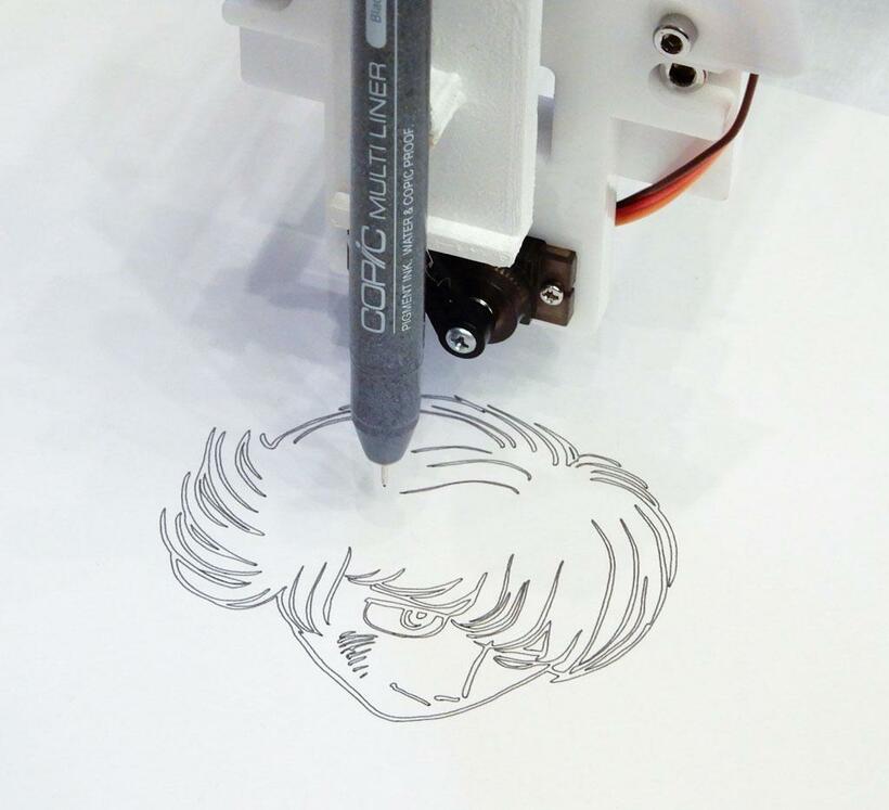 主人公・ぱいどんを描くロボットアーム。ＡＩが描き上げたキャラクターをもとに、下絵の一部も担った（撮影／澤田憲）