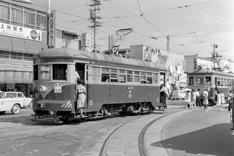 暑かった夏の日、新清水で乗車扱い中の横砂行きモハ57。後方には新清水止まりで、手前に伸びる軌道を使って新清水駅の電留線に入庫するモハ66が写っている。（撮影／諸河久：1964年8月7日）