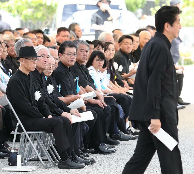 18年6月の沖縄全戦没者追悼式典で、あいさつに向かう安倍首相に厳しい視線を向ける参加者たち（C）朝日新聞社