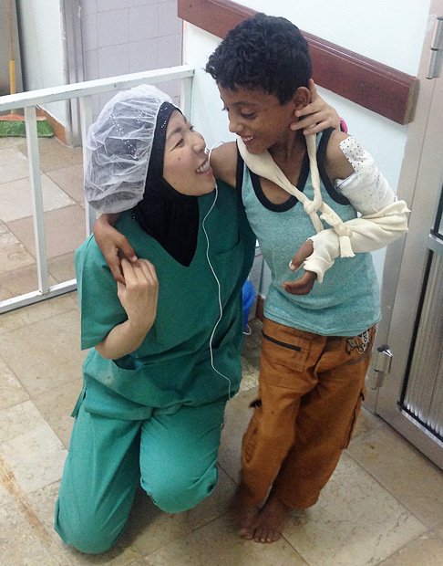 イエメンの病院で空爆被害の子どもの処置をして、笑顔で励ます白川優子さん（2017年1月／写真：国境なき医師団提供）／http://www.msf.or.jp/