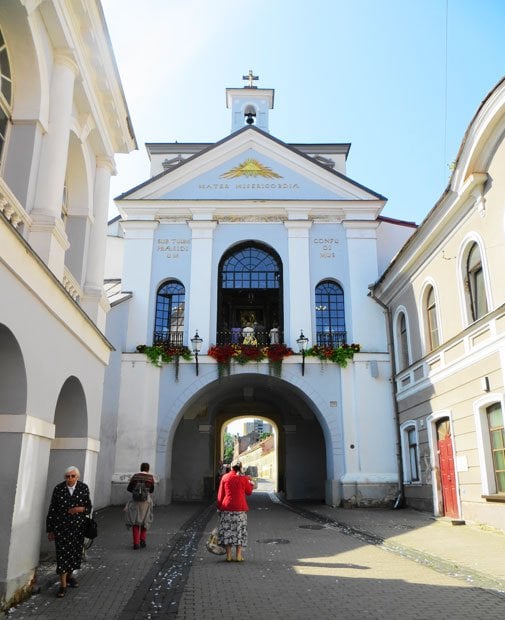 ヴィリニュス　　夜明けの門のチャペル。16世紀、敵の攻撃から街を護り旅行者を祝福するために、門には宗教的なモニュメントが造られた。ここには奇跡を起こす聖母マリアのイコンがあり、リトアニア国内だけでなくポーランドからも巡礼者が訪れる。日曜日の今日はミサが行われていて、通りがかりの人たちも窓の下で祈りを捧げていた