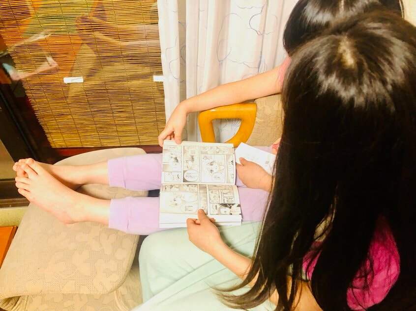 仲良くマンガを読む藤井セイラさんの娘たち(photo 本人提供)