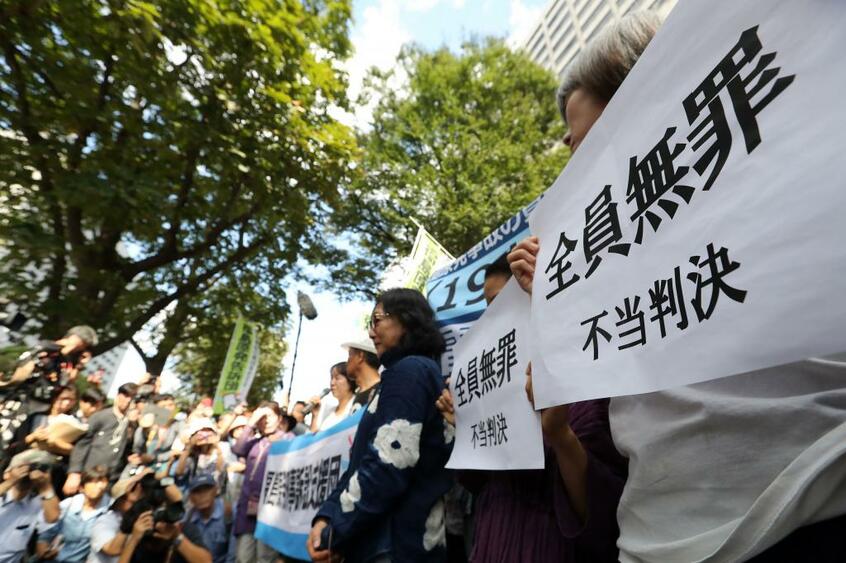 東京電力旧経営陣3人に対する無罪判決を受けて、東京地裁前で集会を行う福島原発刑事訴訟支援団のメンバー (c)朝日新聞社
