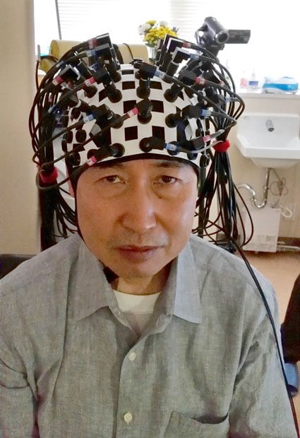 頭にイメージング装置の装着プローブをつけると、配線が多数あって少し重い（写真：本人提供）