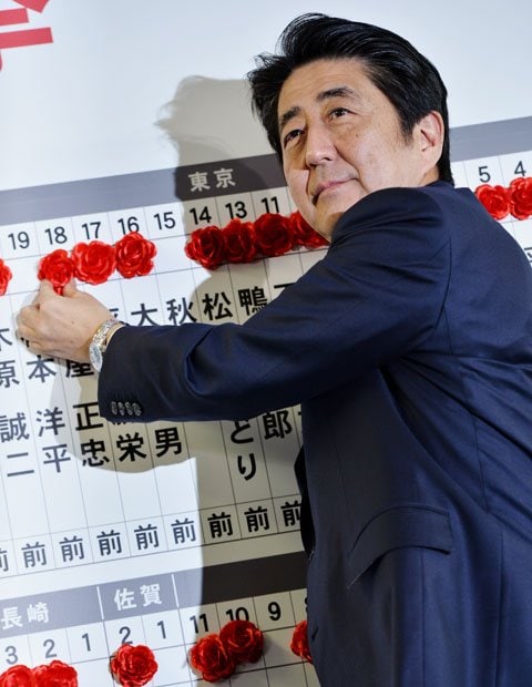 候補者の名前が並んだボードに「花付け」する安倍晋三首相（撮影／写真部・東川哲也）