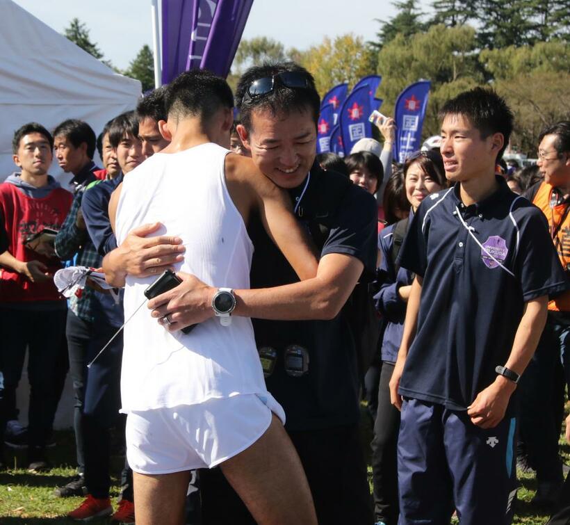 予選会のレース後、選手と抱き合う筑波大の弘山勉監督（Ｃ）朝日新聞社