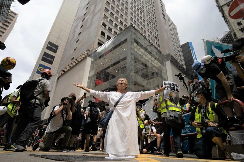 7月1日の午後、ハイブランドのショップなどが立ち並ぶ銅鑼灣（コーズウェイ・ベイ）の路上で「国安（法）恐れず、民権に光あれ」というプラカードを手に神に祈る女性（写真／Kaoru Ng）