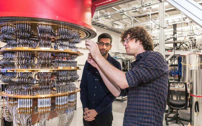 グーグルのスンダー・ピチャイCEO(写真左)が量子コンピューター「シカモア」が収められた冷凍機の前で見守る中、装置の整備が進められる(写真:Google提供)