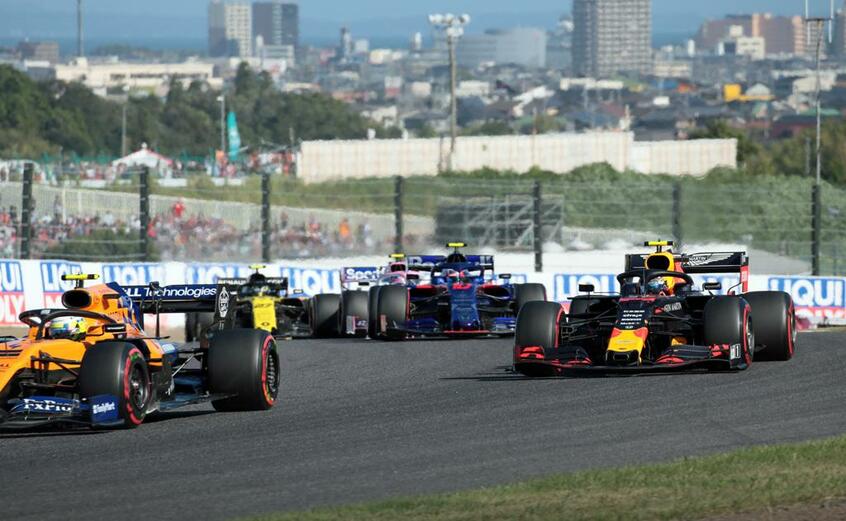 日本GP決勝で鈴鹿の市街地を背景に走るF1マシン。右は4位になったアレクサンダー・アルボン (c)朝日新聞社