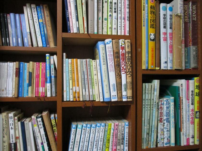 杉政光子さんの子どもたちが使っていた本棚。『宇宙のひみつ』など漫画や図鑑、百科事典がびっしりと並ぶ（写真：杉政光子さん提供）