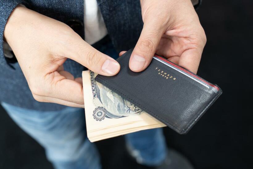 財布は持たず、現金をそのままポケットに入れている。万が一、カードが使えないときのために10万円前後は常に持っているそう。小銭は会社にも自宅にも置いてある「ポケットの中の小銭を入れる瓶」に。クレジットカードなどを入れるパスケースは京都の井澤屋のもの（撮影／小山幸佑）