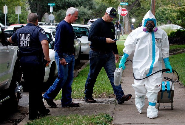 二次感染が確認された看護師宅の前を歩く防護服姿の男性／１２日、米テキサス州ダラス（写真：gettyimagse）