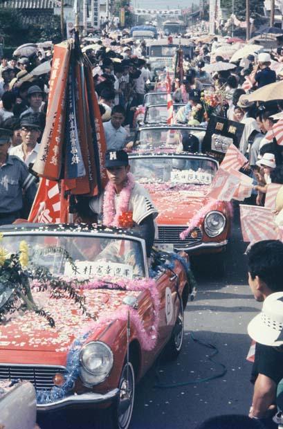 第４７回（１９６５年）、初陣で深紅の大優勝旗を持ち帰った三池工ナインと迎える市民　（ｃ）朝日新聞社