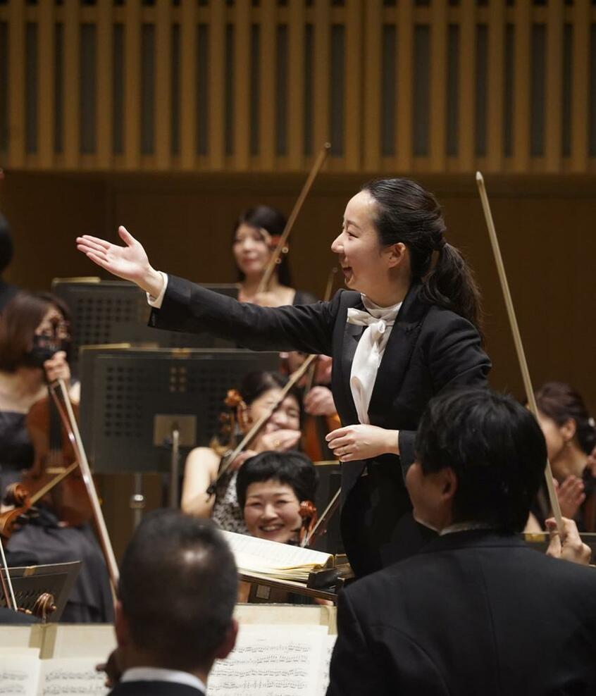 4月14日、京都市交響楽団常任指揮者として初めての演奏が終わり、奏者を称える沖澤。笑顔があふれるデビューコンサートだった。終演後のロビーでも華やいだ人々の会話が続いていた(写真提供・京都市交響楽団)