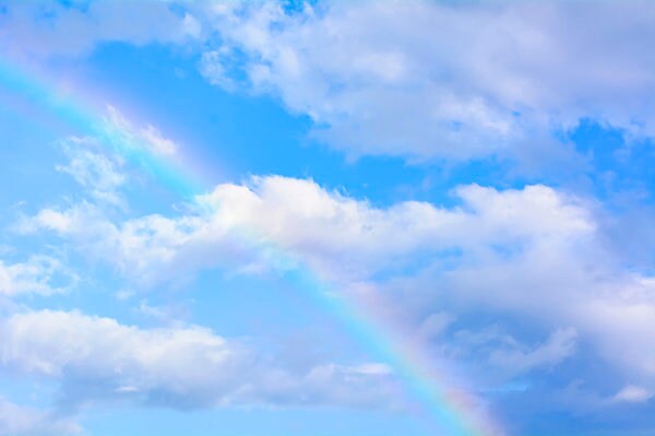 賑やかな夏雲と青空にかかる虹