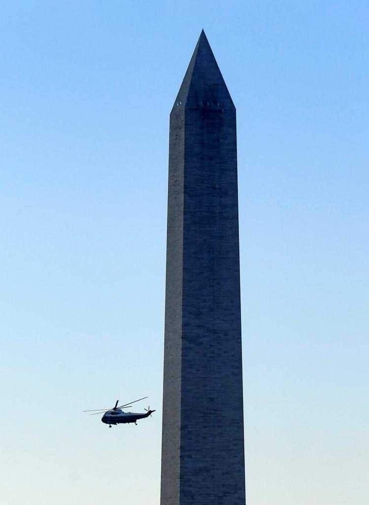独立戦争に勝利し初代大統領となったワシントンの功績をたたえる、大統領職の象徴でもある記念塔を横切るトランプ氏が乗ったヘリ／１月２０日、ワシントン（写真：Nick Ut）