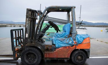 雨の日の黒猫はフォークリフト特訓中「ハンドルをこうやって…こうかニャ?」【沖昌之】
