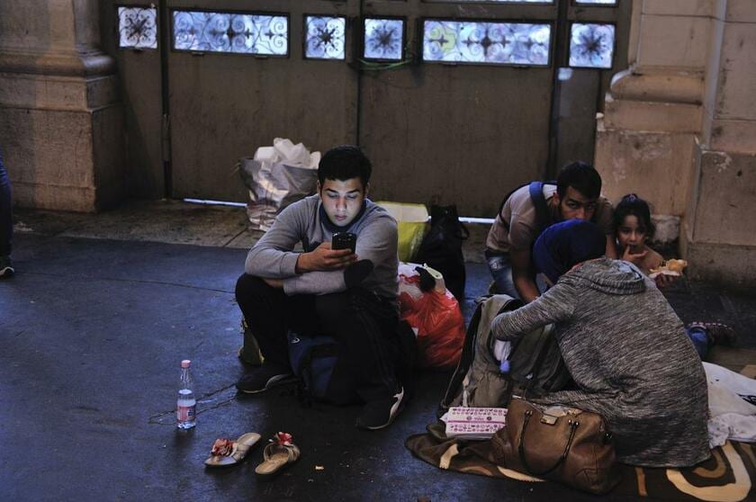 スマートフォンは難民生活に欠かせない。国連難民高等弁務官事務所は２０１６年に「難民のための接続性 Ｃｏｎｎｅｃｔｉｖｉｔｙ ｆｏｒ Ｒｅｆｕｇｅｅｓ」イニシアチブを立ち上げた。ハンガリーのブダペスト東駅でスマートフォンを見る難民　（ｃ）ＵＮＨＣＲ／Ｍａｒｋ Ｈｅｎｌｅｙ