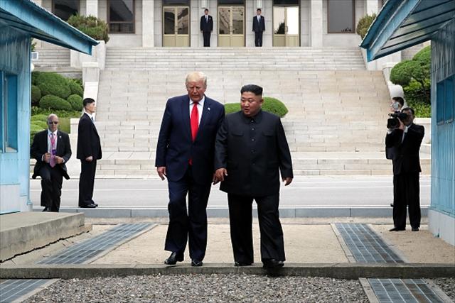 南北境界の板門店で６月３０日、金正恩朝鮮労働党委員長（右）と歩くトランプ米大統領（ｇｅｔｔｙｉｍａｇｅｓ）。軍事境界線の北朝鮮側から韓国側へわたった