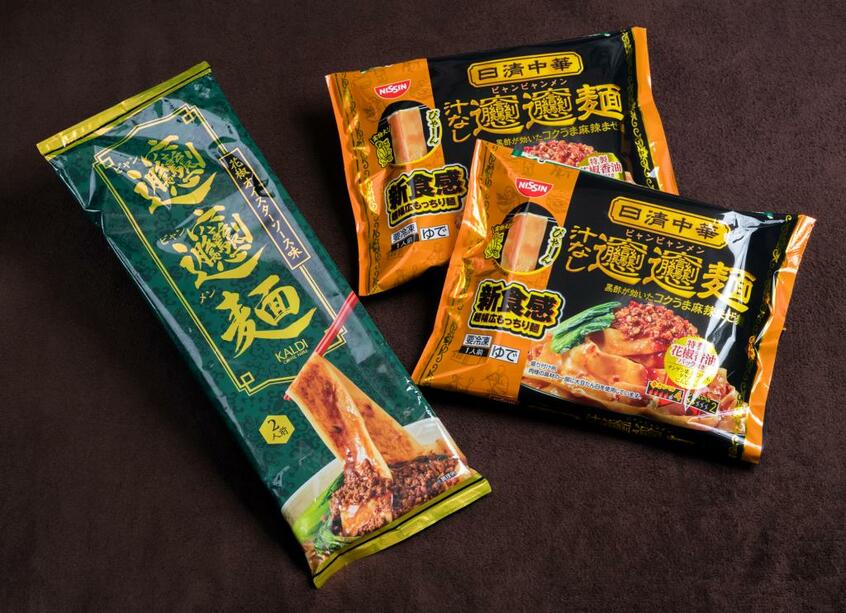 カルディコーヒーファームの「オリジナル ビャンビャン麺 花椒オイスター味」(左)。日清食品冷凍の「冷凍 日清中華 ビャンビャン麺」(photo 横関一浩)